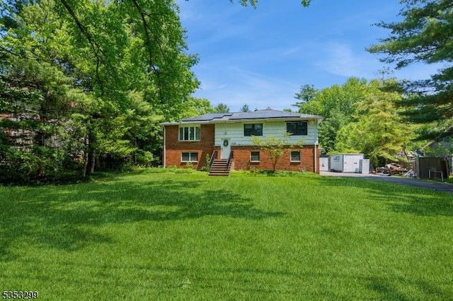 1231 Sunnyfield Ln, Scotch Plains Twp, NJ 07076 - back of house with roof mounted solar panels, a yard, and brick siding