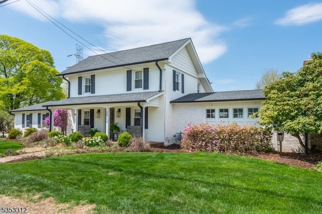 view of front of property featuring a porch, stucco siding, and a front yard