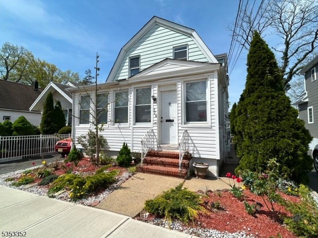 dutch colonial with entry steps, fence, and a gambrel roof