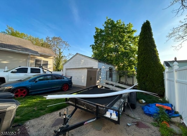 exterior space featuring fence, an outdoor structure, and a garage