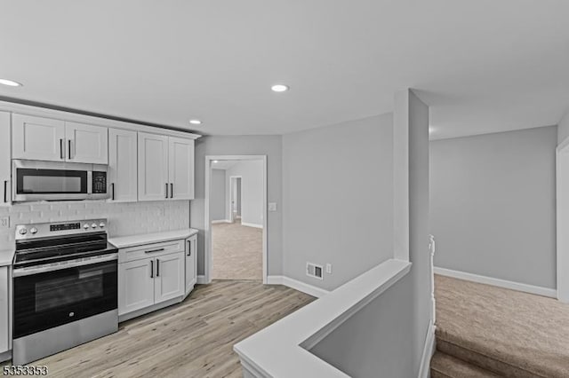 kitchen with stainless steel appliances, light countertops, recessed lighting, tasteful backsplash, and baseboards