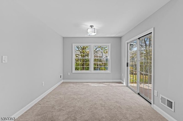 spare room with baseboards and carpet