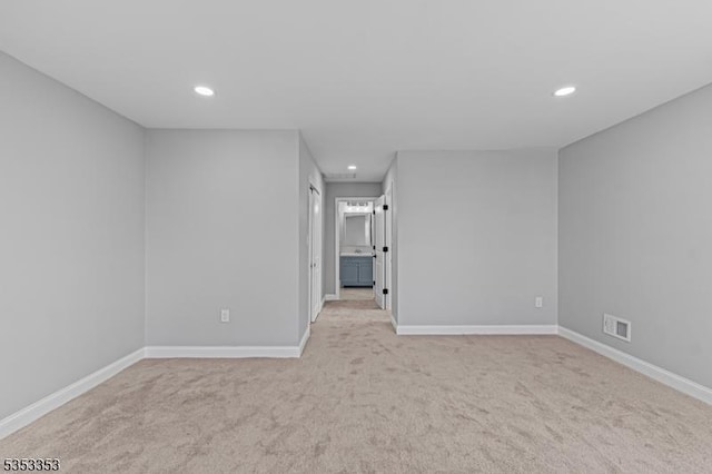 unfurnished room with light colored carpet, recessed lighting, and baseboards