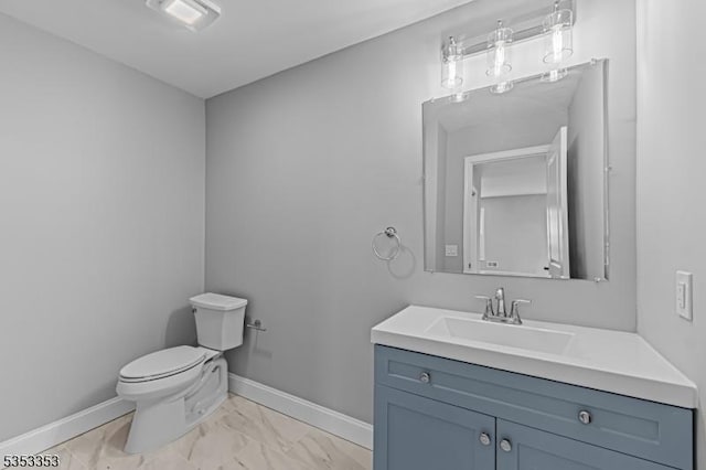 half bathroom featuring marble finish flooring, baseboards, toilet, and vanity
