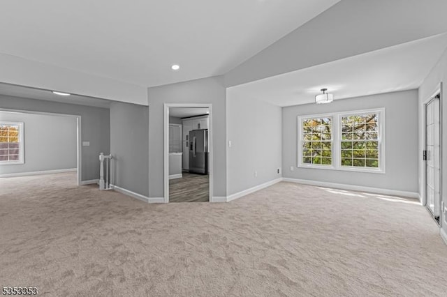 carpeted spare room with healthy amount of natural light, baseboards, recessed lighting, and vaulted ceiling