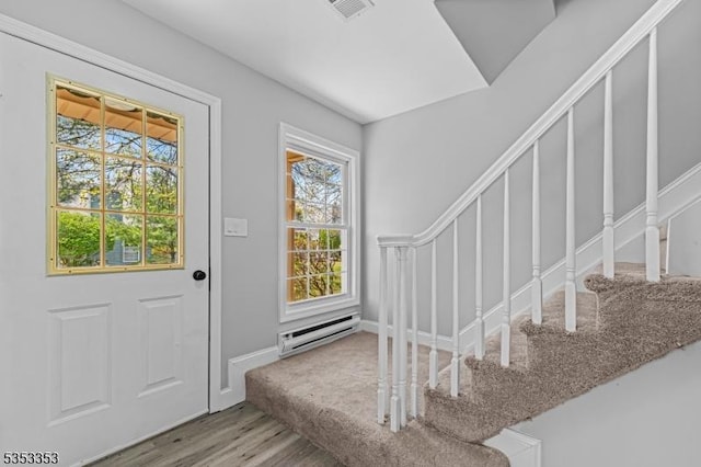 entrance foyer featuring baseboard heating, wood finished floors, and baseboards