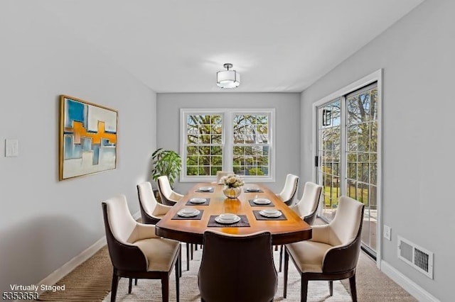 carpeted dining space with healthy amount of natural light and baseboards