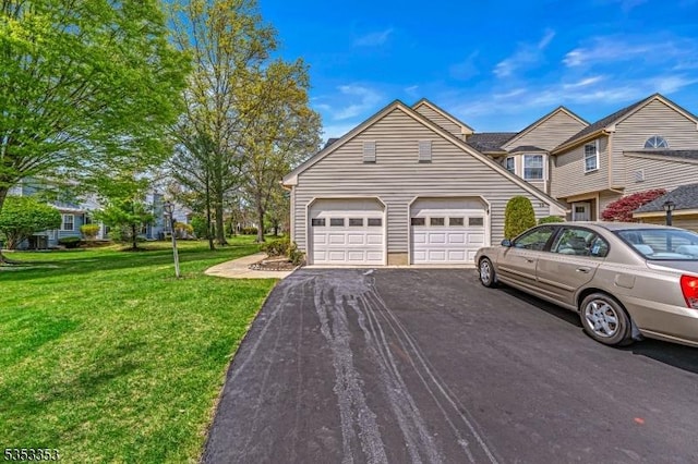 view of front of home featuring asphalt driveway, a front yard, and an attached garage