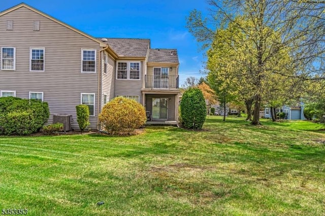 rear view of property with central AC, a yard, and a balcony