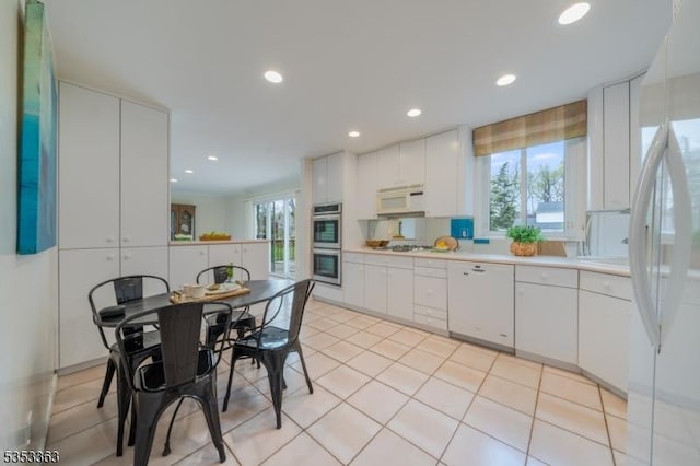 kitchen with white cabinetry, light countertops, white appliances, recessed lighting, and light tile patterned flooring