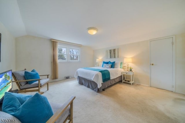 bedroom with lofted ceiling and light colored carpet