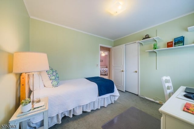 carpeted bedroom with crown molding and a closet