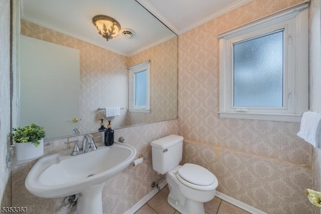 bathroom featuring crown molding, a sink, tile patterned flooring, and toilet