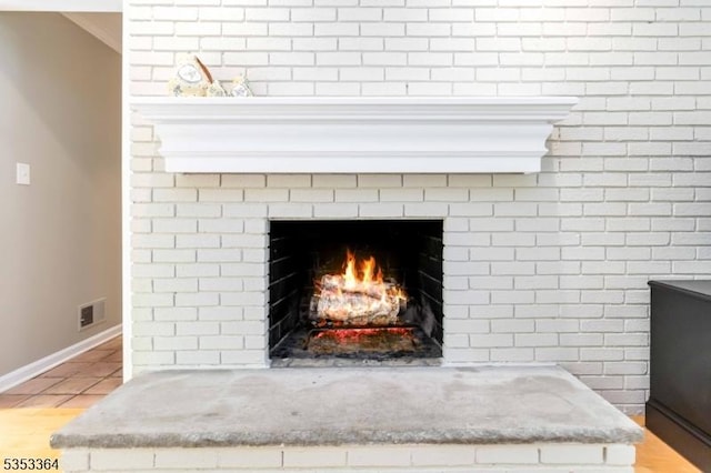 details with visible vents, baseboards, and a fireplace