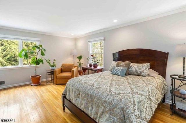 bedroom featuring crown molding, baseboards, visible vents, and hardwood / wood-style floors