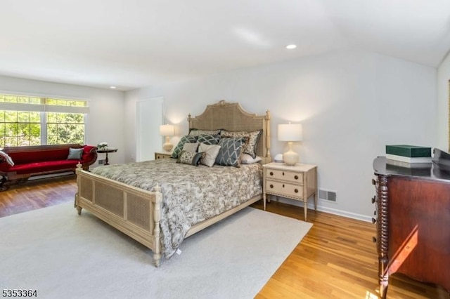 bedroom with visible vents, vaulted ceiling, baseboards, light wood-style floors, and recessed lighting
