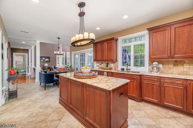14 Jenny Ln, Vernon Twp, NJ 07461 - kitchen featuring a kitchen island, light stone countertops, ornate columns, a sink, and backsplash