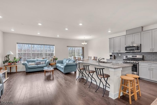 1203 Parkview Ln, Rockaway Twp, NJ 07866 - kitchen with a breakfast bar area, appliances with stainless steel finishes, open floor plan, dark wood-type flooring, and a notable chandelier