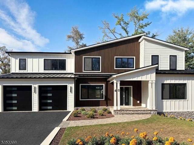 modern farmhouse featuring a standing seam roof, driveway, metal roof, and an attached garage