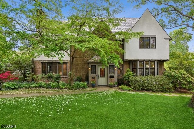 view of front of property with a front lawn and brick siding