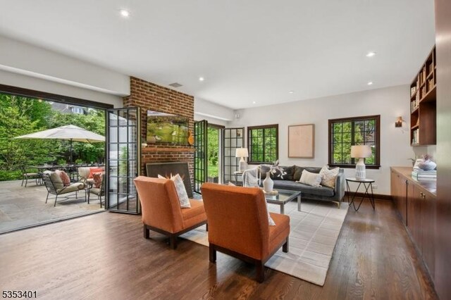 living room featuring wood finished floors, healthy amount of natural light, a fireplace, and recessed lighting