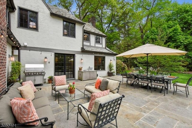 view of patio with an outdoor living space, outdoor dining space, and grilling area