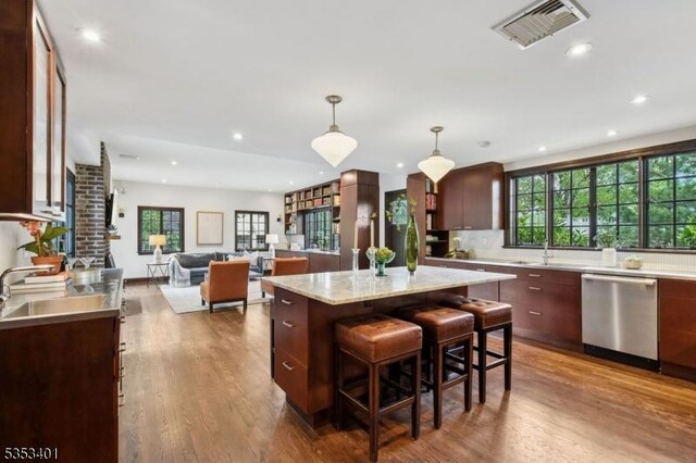 kitchen featuring dishwasher, light countertops, dark wood finished floors, hanging light fixtures, and recessed lighting