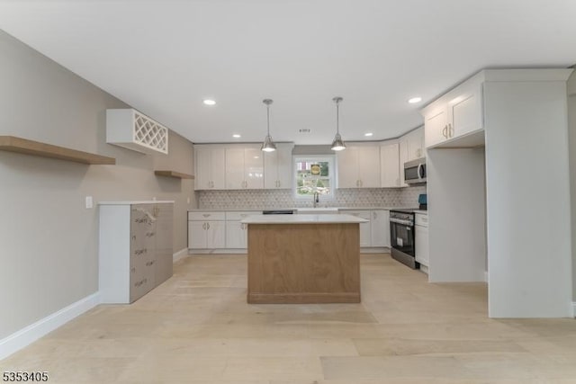 kitchen with backsplash, light countertops, appliances with stainless steel finishes, and a kitchen island