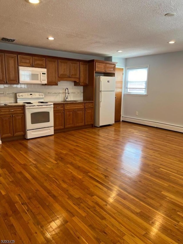 28 W Elizabeth Ave Unit B3, Linden City, NJ 07036 - kitchen with brown cabinetry, a textured ceiling, a sink, white appliances, and dark wood-type flooring