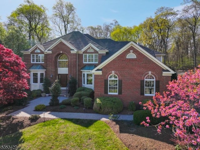 view of front facade with brick siding and a front yard