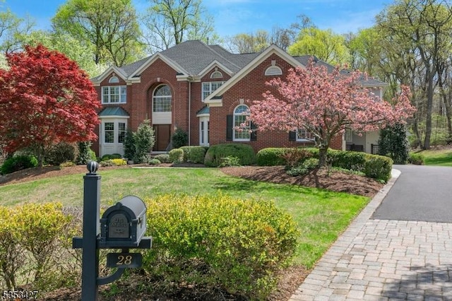 traditional-style home with brick siding and a front yard