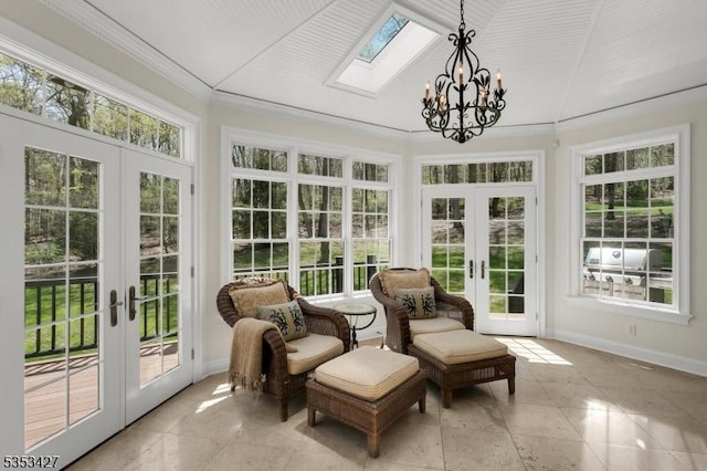 sunroom with french doors, a notable chandelier, and a skylight