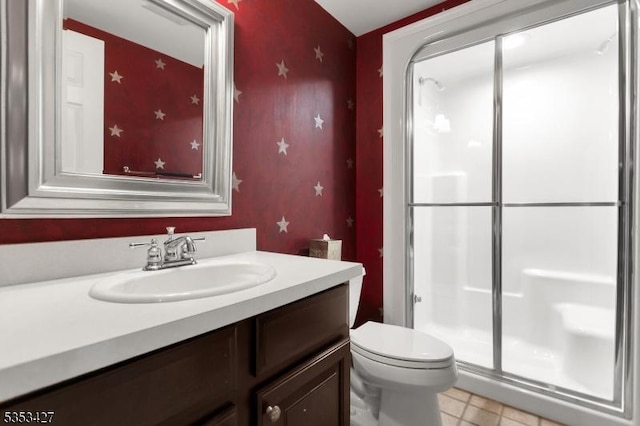 bathroom featuring toilet, tile patterned floors, a shower stall, and vanity
