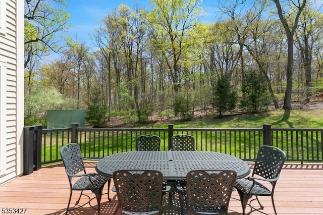 deck featuring a lawn and outdoor dining space