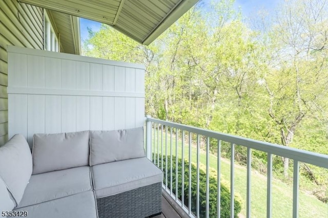 balcony featuring a wooded view