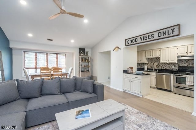 living area featuring recessed lighting, light wood-style floors, ceiling fan, visible vents, and vaulted ceiling