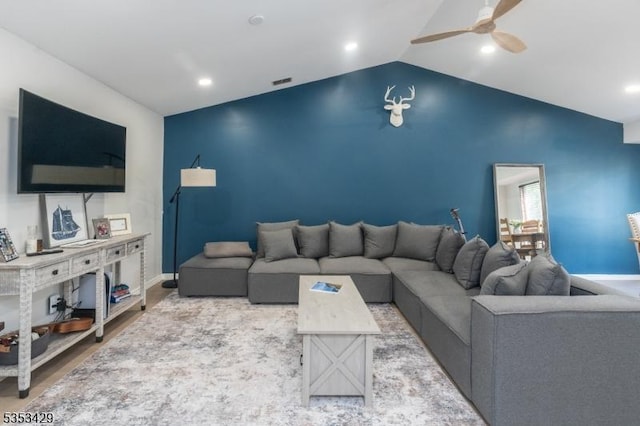 living area with lofted ceiling, ceiling fan, visible vents, baseboards, and wood finished floors