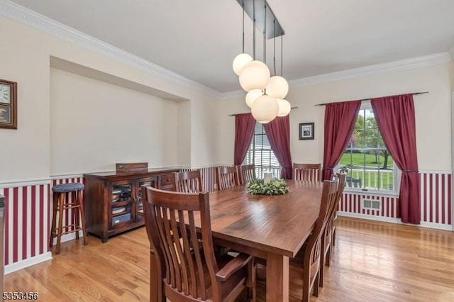 dining room with plenty of natural light, ornamental molding, and wood finished floors