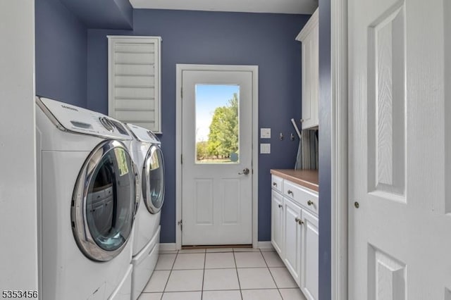 clothes washing area featuring baseboards, cabinet space, independent washer and dryer, and light tile patterned floors