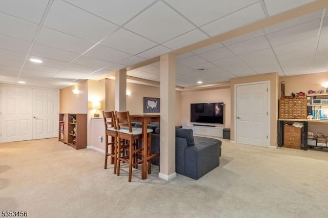 carpeted living area with recessed lighting, baseboards, and a drop ceiling