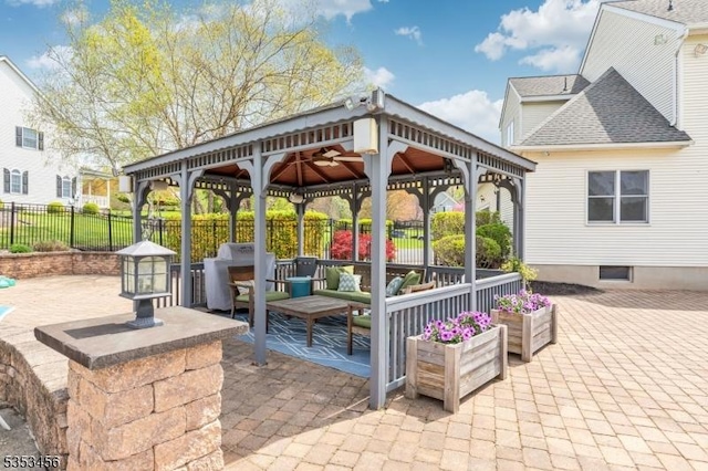 view of patio / terrace with a gazebo, an outdoor living space, and fence