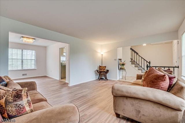 living area featuring stairs and light wood finished floors