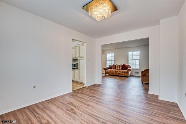 interior space with baseboards and light wood finished floors