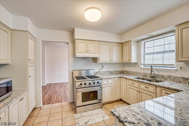 kitchen featuring a sink, appliances with stainless steel finishes, under cabinet range hood, and cream cabinetry