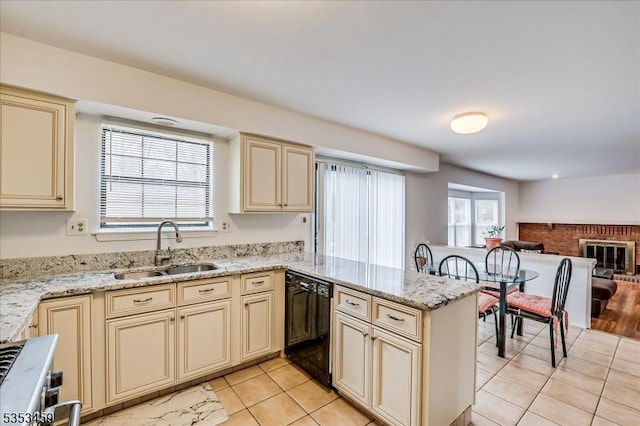 kitchen with dishwasher, a sink, light tile patterned floors, a peninsula, and cream cabinetry