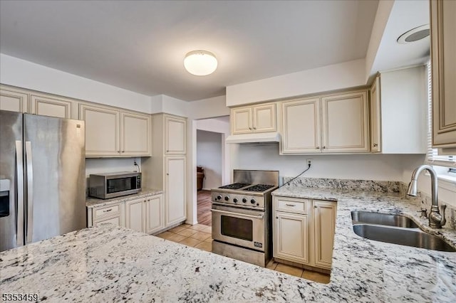 kitchen with a sink, appliances with stainless steel finishes, and cream cabinets