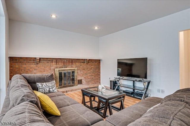 living room with recessed lighting, visible vents, wood finished floors, and a fireplace