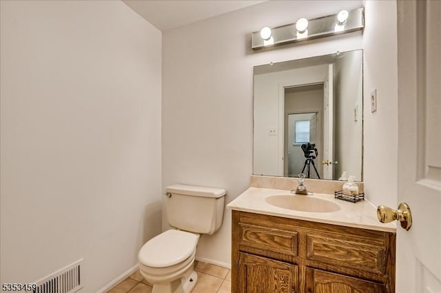 half bathroom with tile patterned flooring, vanity, toilet, baseboards, and visible vents