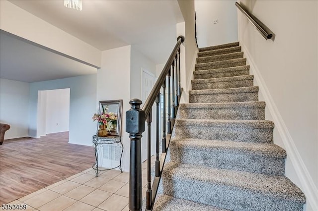 stairs featuring tile patterned floors and baseboards