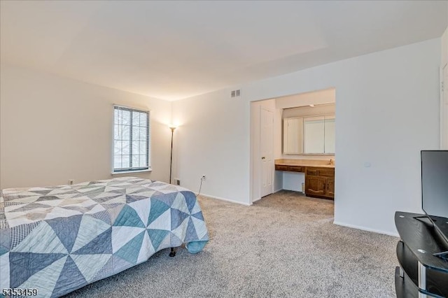 bedroom with baseboards, light carpet, connected bathroom, and visible vents
